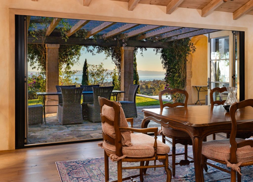 Dining area at 965 Brooktree Road opening onto a covered loggia with ocean views